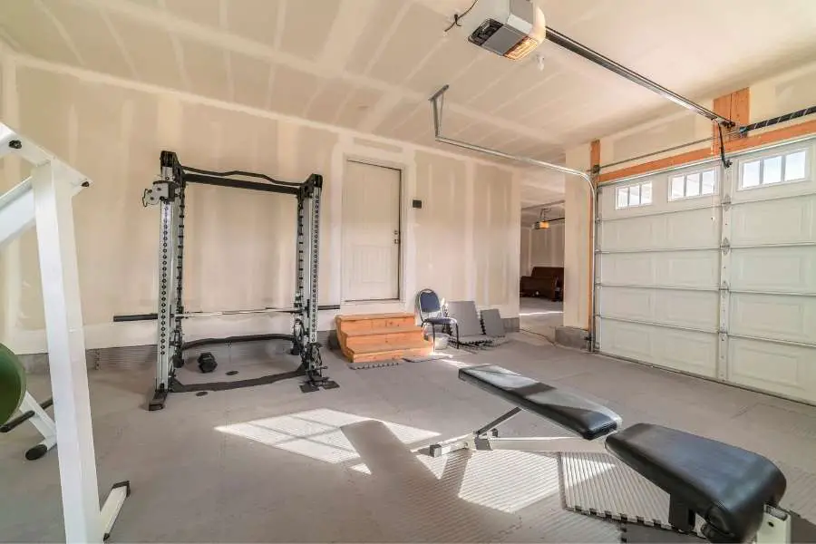 Image of a squat rack and bench in a garage gym.