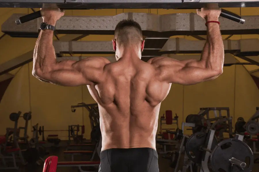 Man with strong back muscles doing pull ups