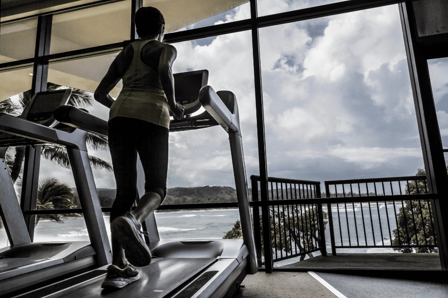 Image of a woman on a treadmill in front of the ocean.